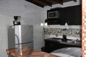 a kitchen with a refrigerator and a microwave at Aparta Suite Torre De Prado 503 in Medellín