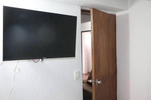 TV de pantalla plana colgada en la pared en Aparta Suite Torre De Prado 503, en Medellín