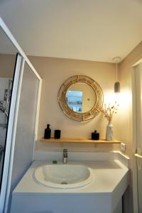 La salle de bains est pourvue d'un lavabo et d'un miroir. dans l'établissement La cabanette du sunset 5 *100m de la mer*, à Guidel