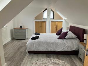 a bedroom with a large bed in a attic at Surfers Lodge - Rest Bay, Porthcawl in Porthcawl