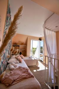 een slaapkamer met 2 bedden en een groot raam bij La cabanette du sunset 5 *100m de la mer* in Guidel