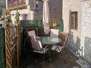 stół i krzesła z parasolem na patio w obiekcie Casa Rural La Peña en Unquera (Cantabria) w mieście Unquera