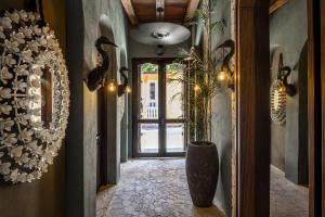 einen Flur mit Vase und eine Tür mit Pflanze in der Unterkunft Privado Selfservice Boutique Rooms in Cartagena de Indias