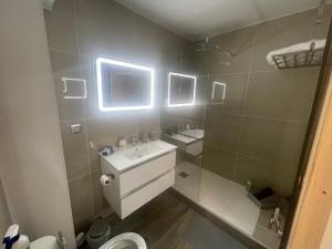 a bathroom with two sinks and a mirror at Superbe maison Tout Confort Parking Netflix 