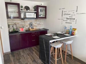 a kitchen with purple cabinets and a counter with stools at Superbe maison Tout Confort Parking Netflix 