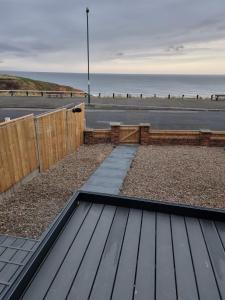 a wooden deck with a view of the beach at Salt & Surf-Sea Views in Saltburn in Saltburn-by-the-Sea