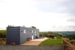 a tiny house on a hill with a deck at Cwm Heulog in Knighton