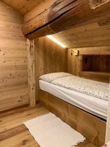 a bedroom with a bed in a wooden cabin at Flora Alpina apartments-Residenza Verdebjo in Gressoney-Saint-Jean