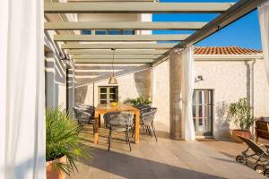 een patio met een houten tafel en stoelen bij Villa Moonlight in Štuti