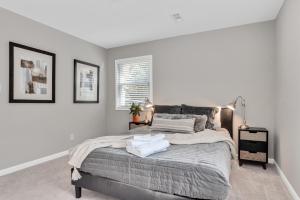 a bedroom with a large bed with white walls at Cozy 3BR home fully fenced and in quiet street, 5min to downtown, 10min to Duke and RTP in Durham