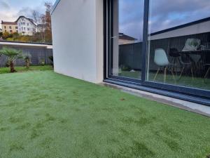 a yard with green grass on the side of a house at Maison avec jacuzzi et sauna in Épinal