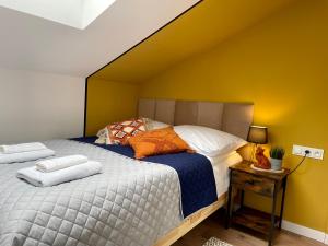 - une chambre avec 2 lits et un mur jaune dans l'établissement Apartament za Ratuszem - z balkonem, à Radom