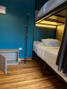 a bedroom with a bed and a blue wall at Bendito Hostels in Bogotá