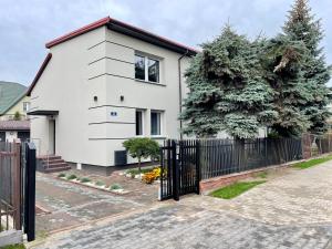 une maison blanche avec une clôture noire dans l'établissement Apartament za Ratuszem - z balkonem, à Radom
