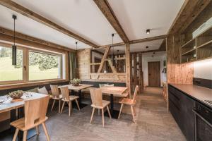 - une cuisine avec des murs en bois, des tables et des chaises dans l'établissement Biohof Untergröber, à Braies