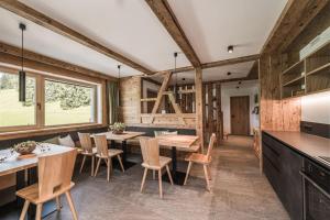 a kitchen with wooden walls and tables and chairs at Biohof Untergröber in Braies
