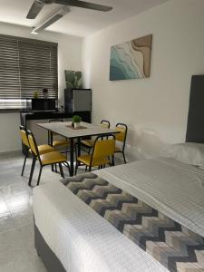 a bedroom with a bed and a table and chairs at Departamento Cancún in Cancún