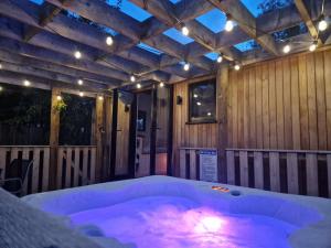a jacuzzi tub in a room with a wooden ceiling at Wren - Luxury Shepherd's Hut with Hot Tub in Manea