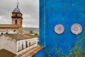 due piatti su un muro blu accanto a una chiesa di Hostal Forum a Villa del Río