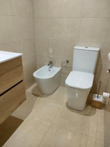 a bathroom with a white toilet and a sink at Villa Piomincha in Cee +14 photos