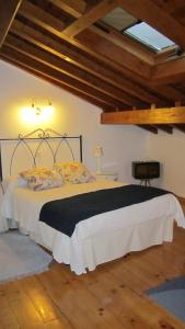 a bedroom with a bed in a room with wooden floors at Casa de la Parra in Mogarraz