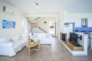 ein Wohnzimmer mit einem weißen Sofa und einem TV in der Unterkunft Villa Melissa Selana in Protaras