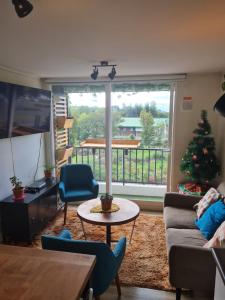 una sala de estar con un árbol de Navidad en el balcón en Departamento Osorno 215, en Osorno