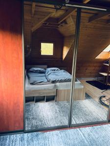 a small bed in a wooden cabin with a window at Tantra klub - private room in a shared wooden house in Prague