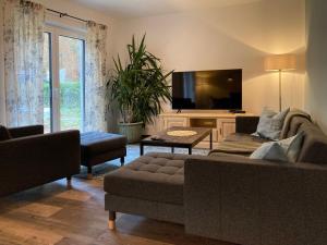 a living room with a couch and a flat screen tv at Ferienhaus am Hafen in Klausdorf Mecklenburg Vorpommern