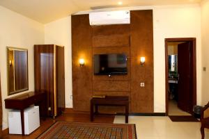 sala de estar con TV de pantalla plana en la pared en Shelton Residency Lahore, en Lahore