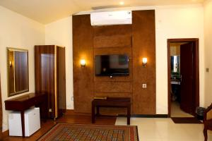 a living room with a flat screen tv on a wall at Shelton Residency Lahore in Lahore