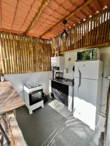 a kitchen with a refrigerator and a stove at Coco Suites in Abraão