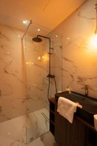 a bathroom with a glass shower and a sink at New upscale central maarif flat in Casablanca