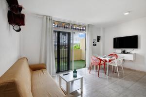 a living room with a couch and a table with chairs at Apartamento Caletillas Alan in Candelaria