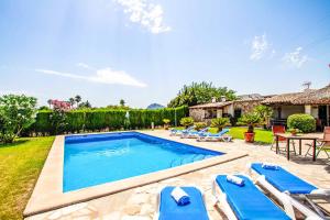 una piscina con sedie blu e una casa di Villa Bosque a El Port