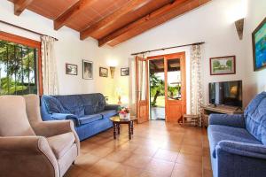 un soggiorno con divani blu e TV di Villa Bosque a El Port