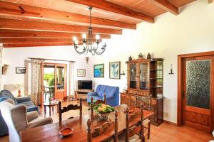 a living room with a table and blue chairs at Villa Bosque in El Port
