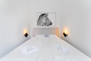 a bedroom with a white bed with two white towels at Center Wien designer central modern apartment in Vienna