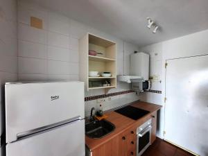 a kitchen with a white refrigerator and a sink at Estudio Regency Alcaidesa in La Alcaidesa