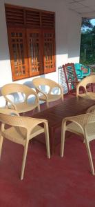 Une table et des chaises en bois sont disponibles sur la terrasse. dans l'établissement Impress Holiday Home, à Anurâdhapura