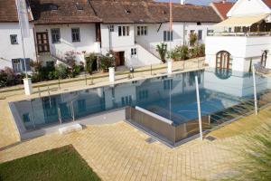 - une vue sur la piscine dans une maison dans l'établissement Das-Schmidt Privathotel, à Mörbisch am See