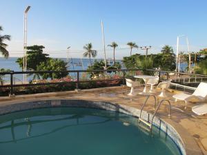 a swimming pool with chairs and a view of the ocean at Particular Golden Beira Mar in Fortaleza