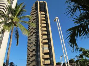 a tall building with palm trees in front of it at Particular Golden Beira Mar in Fortaleza