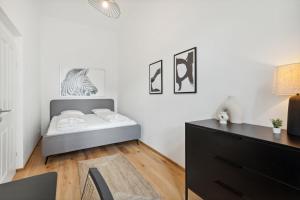 a bedroom with a bed and a dresser at Center Wien designer central modern apartment in Vienna