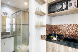 a bathroom with a glass shower and a sink at Particular Golden Beira Mar in Fortaleza
