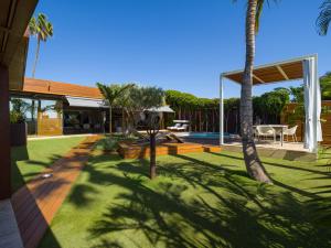 une maison avec une cour dotée d'une piscine et de palmiers dans l'établissement Villa Kai by Maspalomas Holiday Villas, à Pasito Blanco
