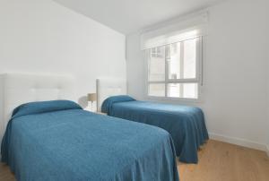 deux lits dans une chambre blanche avec une fenêtre dans l'établissement Apartamento de lujo de 2 dormitorios, à Torrox Costa 20 autres photos