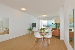 une salle à manger et un salon avec une table et des chaises dans l'établissement Apartamento de lujo de 2 dormitorios, à Torrox Costa