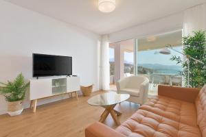 un salon avec un canapé et une télévision dans l'établissement Apartamento de lujo de 2 dormitorios, à Torrox Costa