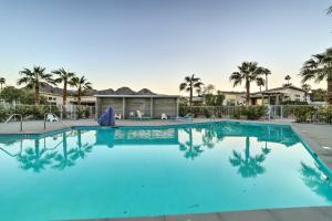 a swimming pool with palm trees in the background at Sleek and Modern Home with Views and Pool Access in Indian Wells